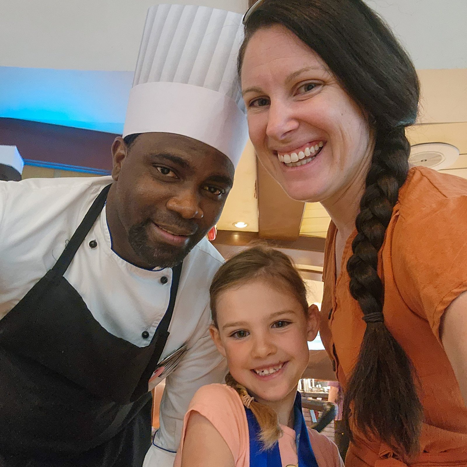 Woman with her child and the chef smiling for a photo