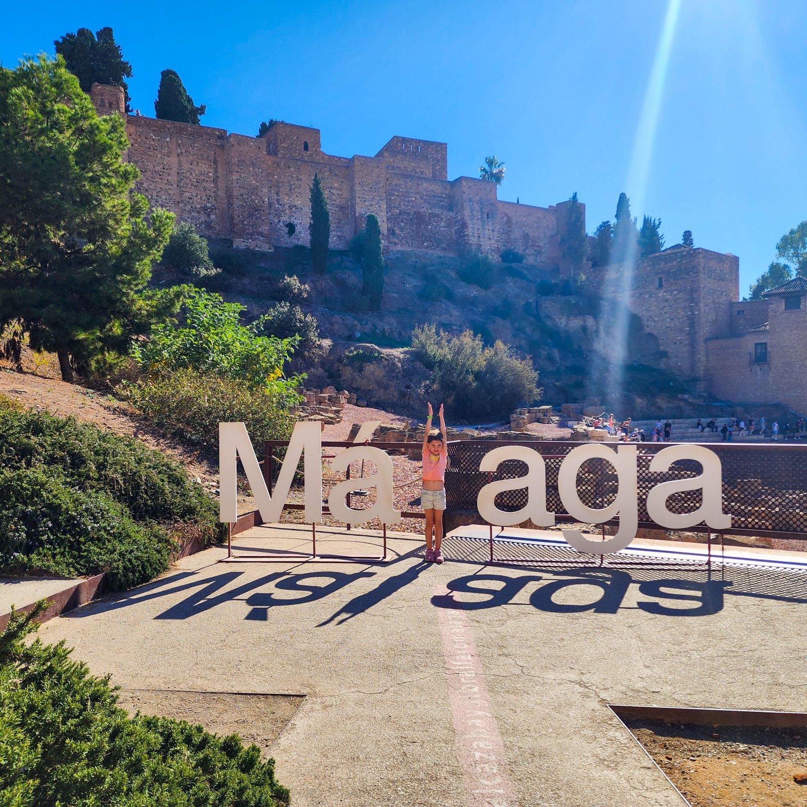 Malaga sign with city ruins in the background