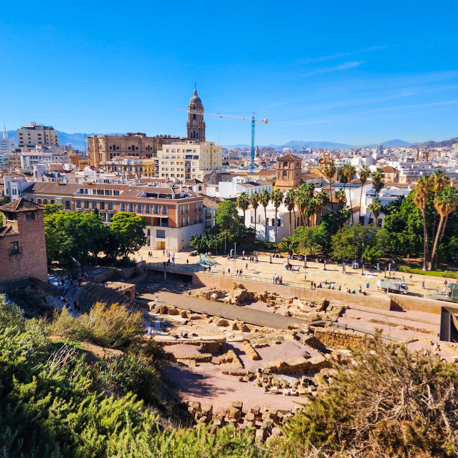 View over Malaga old city ruins with housing a church and other buildings in the distance